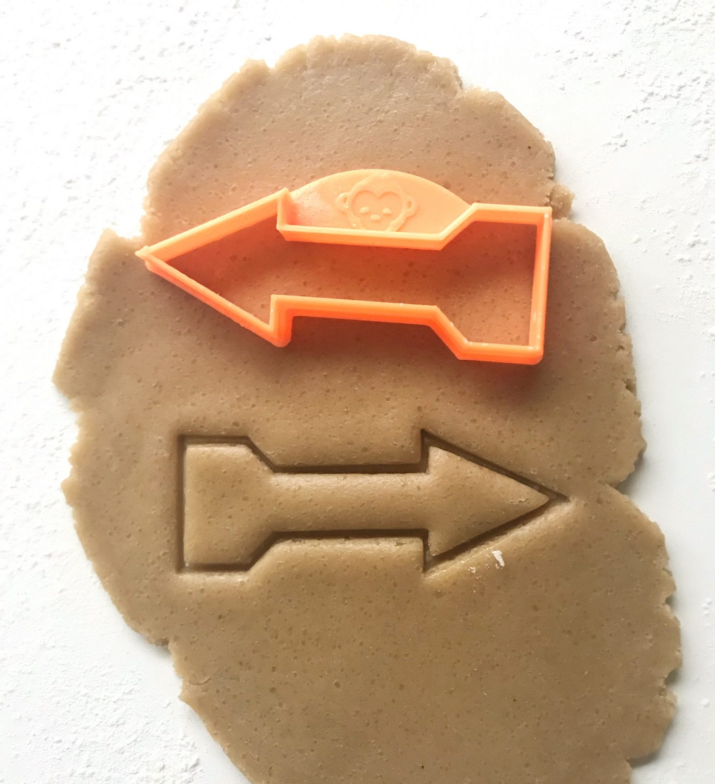 orange arrow cookie cutter on dough